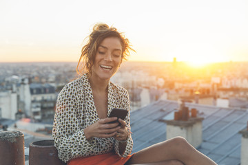 Woman using a smart phone on the roofs of Paris
