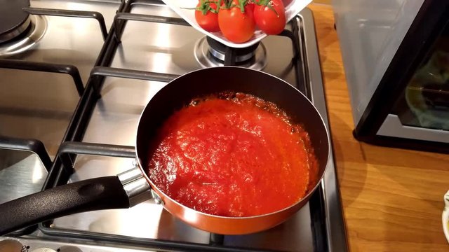 Padella con salsa di pomodoro che cuoce su fornello