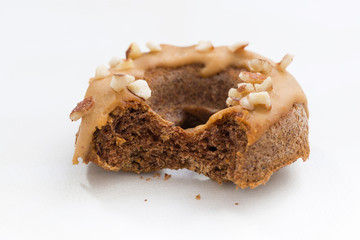 homemade baked donuts with icing on white table, closeup