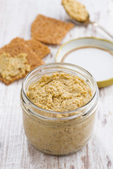homemade mustard in a glass jar and crackers, top view