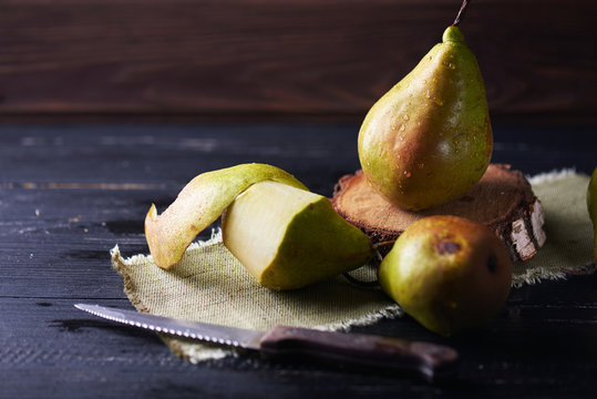 Fresh green pears and knife on a rustic background on a napkin. Vertical shot