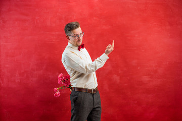 Man holding bouquet of carnations behind back