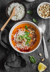Thai carrot sweet potato soup with rice on the dark table, top view. Flat lay