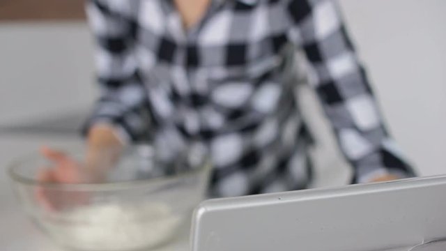 Young woman cracking eggs into the bowl
