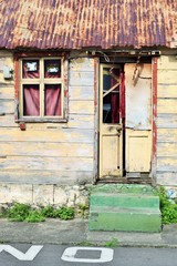 Eingang eines typisches Holzhauses mit Wellblechdach sowie kaputten Fenster und Türen in Roseau, Hauptstadt von Dominica in der Karibik