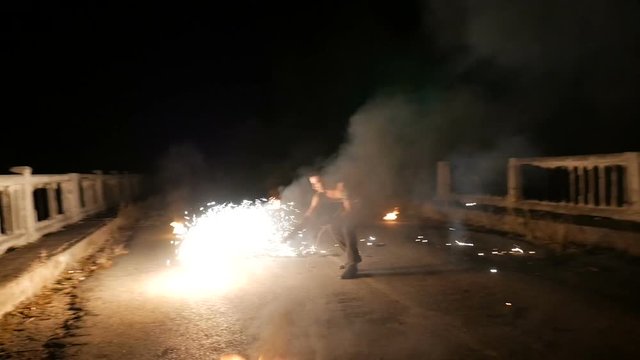 man turns the ball of fire in the dark. go sparks