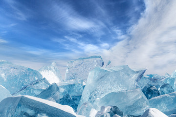 Blocks of broken blue ice on sky background
