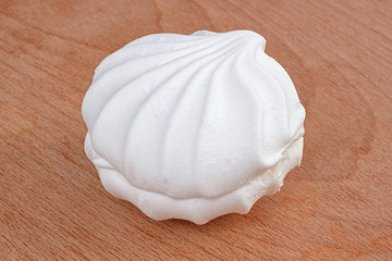 One white airy sweet marshmallow zephyr on wooden background
