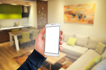 Hand holding smartphone in apartment, hotel mockup - empty screen
