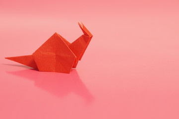 Paper origami snail isolated on a colorful background