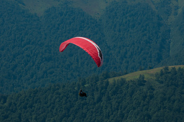 View of a paraglider above the mountain valley. Paragliding over Carpathian mountains. 