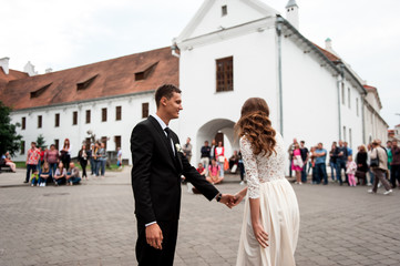 gorgeous happy wedding couple walking and kissing in the old city of Minsk, Belarus