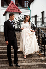 Fototapeta premium gorgeous happy wedding couple walking and kissing in the old city of Minsk, Belarus