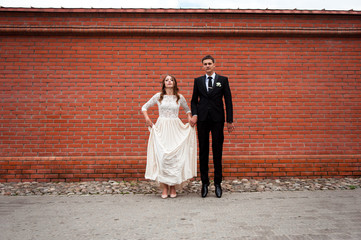 gorgeous happy wedding couple walking and kissing in the old city of Minsk, Belarus