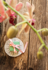 A gift on a white napkin andorchidea on the wooden background