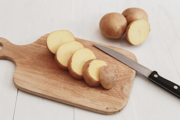 Sliced potatoes on a wooden board rustic style with knife