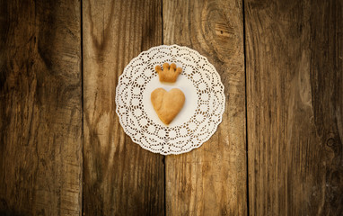 cookies in the shape of a heart and cookies in the shape of a crown on a white napkin on a wooden...