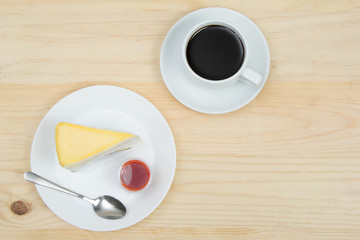 top view of crape cake with strawberry sauce and cup of coffee