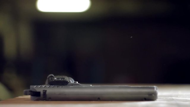 Man puts a gun on the table close-up
