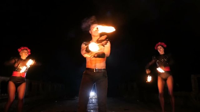 girl and guy dancing with fire in the dark