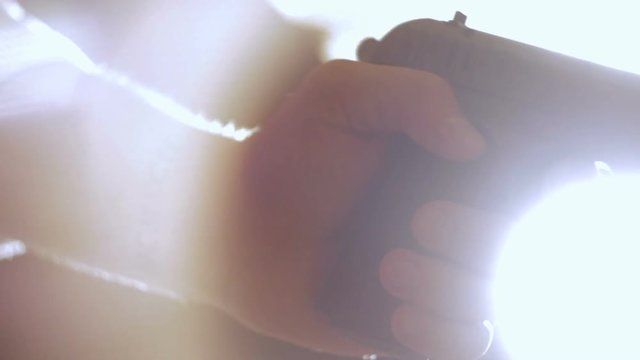 Man cocks the gun. Close-up of hand