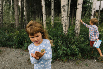 Boy and girl exploring birch trees 