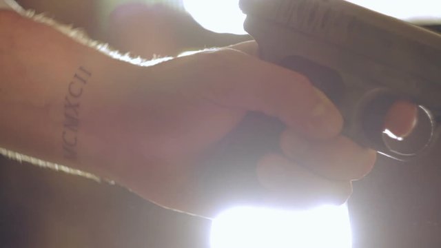 Man cocks the gun and shoots. Close-up of hand