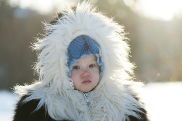 Little girl in a fur coat in the winter park - 133803843