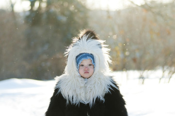 Girl in black and white fur coat in the winter park - 133803844