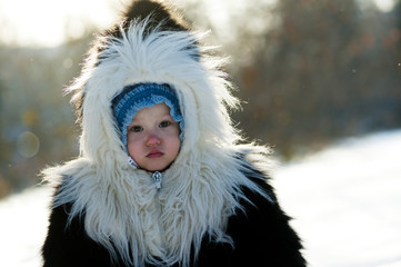 Little girl in a fur coat from natural fur - 133803860