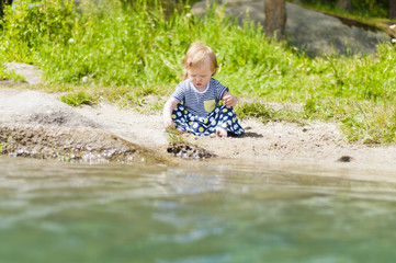 Little girl playing on the river bank