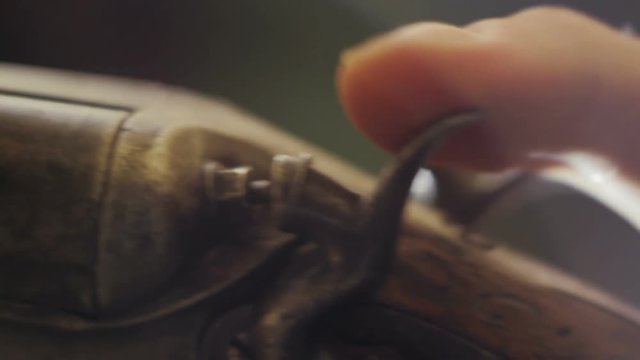 Man cocks the shotgun. Close-up of finger