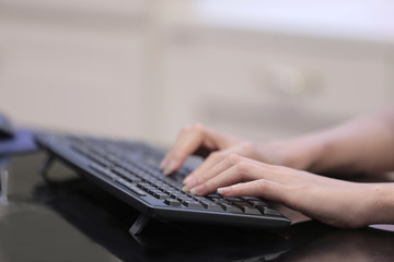 Two hands typing on a keyboard