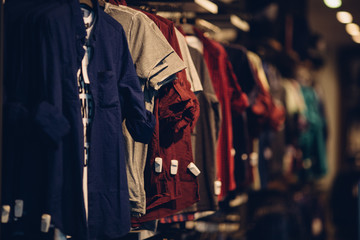 Shirts in men clothing store. Men clothes in shopping mall - obrazy, fototapety, plakaty