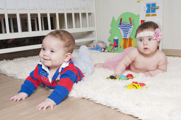 boy and girl playing together on the carpet at home or in the ki