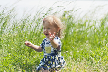 Cheerful girl sitting in tall grass