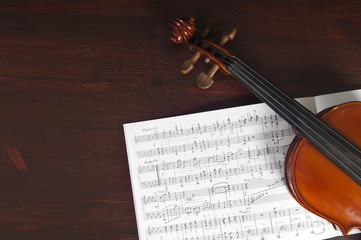 Music notes and violin on table