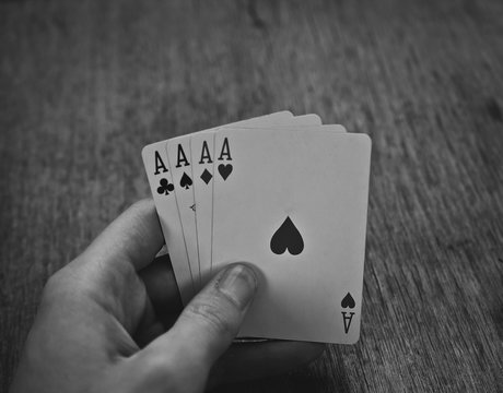 Hand with playing cards (four Aces),