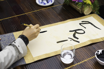 Calligrapher painting words on paper. Calligraphy is a traditional culture in Eastern lunar new...
