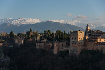 Fototapeta na wymiar View of Alhambra Palace in Granada, Spain with Sierra Nevada mountains in snow at the background . Granada, Spain.