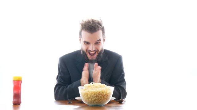 Ecstatic mad businessman eating pasta on the table. Overeating and crazy greedy consumerism concept, studio isolated on white background.