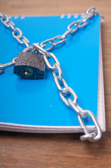 Fototapeta na wymiar Blue notebook, tied with chains with lock