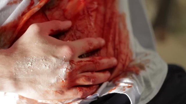 Man with a bleeding wound in the belly close-up