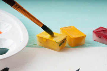 A man takes a brush watercolor paint before painting