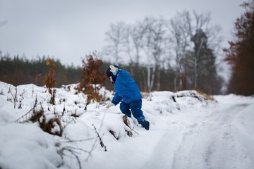 Fototapeta na wymiar Happy little boy playing outdoor in winter snow