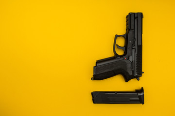 Black gun on a yellow background