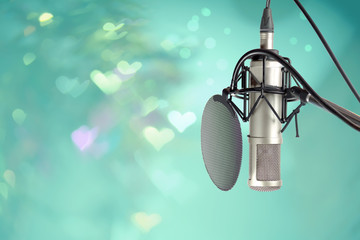 Microphone setting ready for DJ in celebration party valentine’s day.
Colourful heart  bokeh in front of microphone ,retro style.