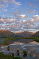 Mountains in sunset light and reflections in the lake. Ridge Cherskogo. Yakutia. Russia.