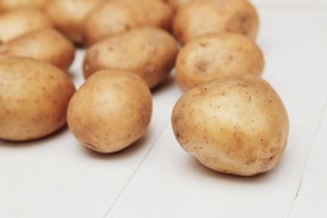 Close up of new potatoes on the white wooden table