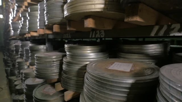 Film Archive. Films, movie reels on a shelfs in a huge old movie archive. 4K.
